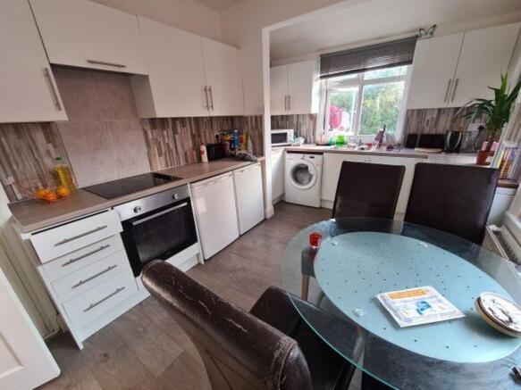 A modern, well-lit kitchen with white cabinetry...