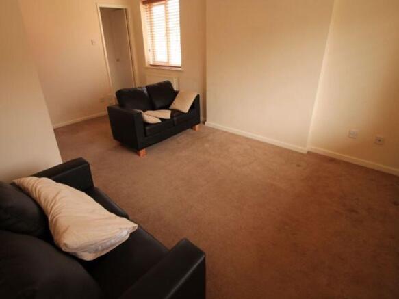 Bright, neutrally decorated living room with co...