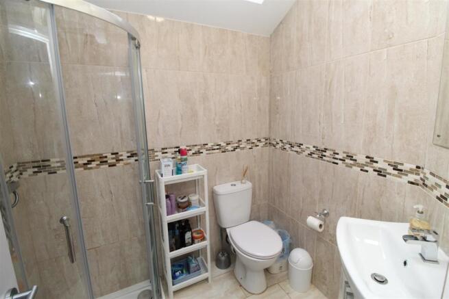 Modern tiled bathroom with a curved glass showe...