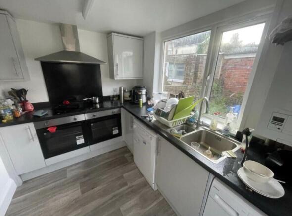 Bright galley kitchen with large window overloo...