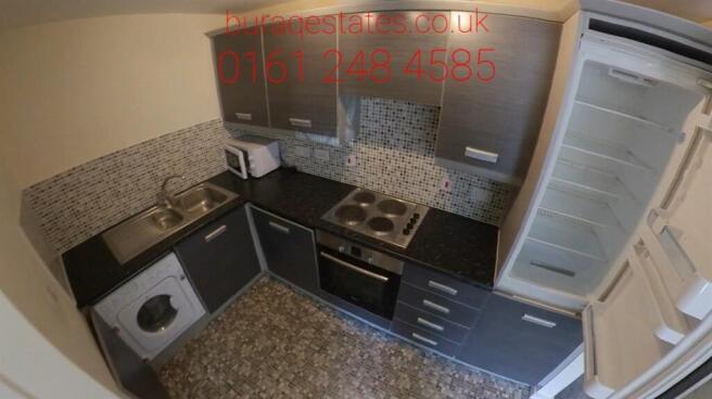 Compact modern kitchen with dark cabinetry, til...