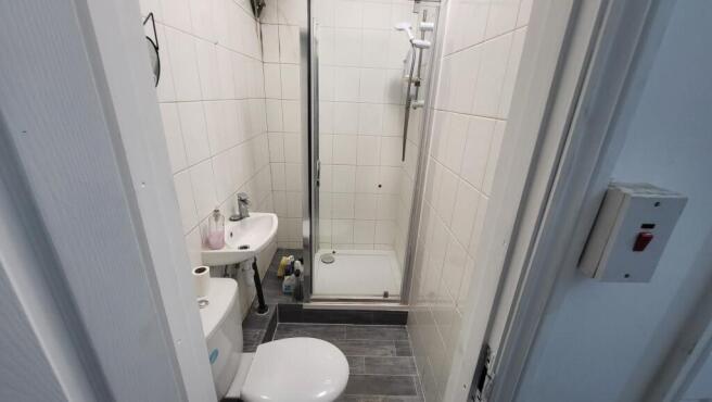 Compact tiled bathroom with a walk-in shower, c...