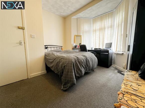 Bright master bedroom with large bay window des...