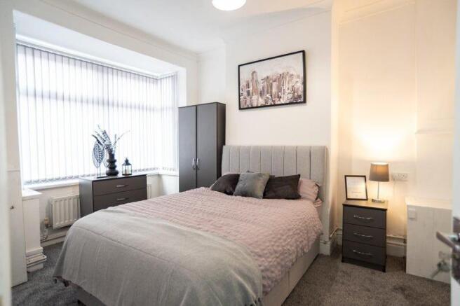 Bright, neatly styled double bedroom with a com...
