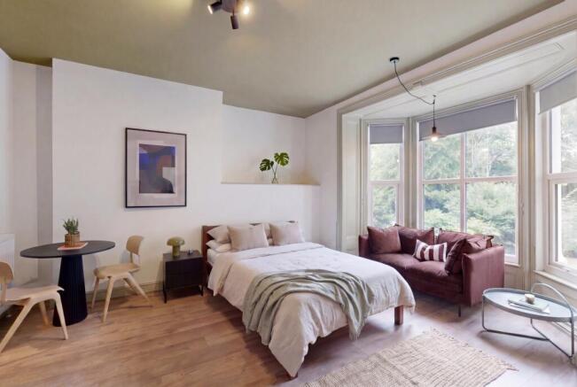 Bright, stylish bedroom with bay window seating...