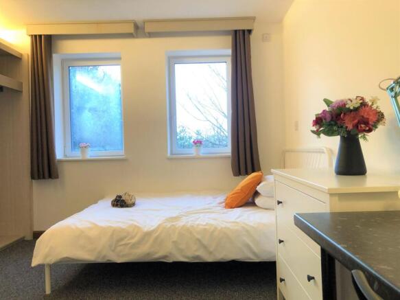 A clean and tidy single bedroom featuring two l...