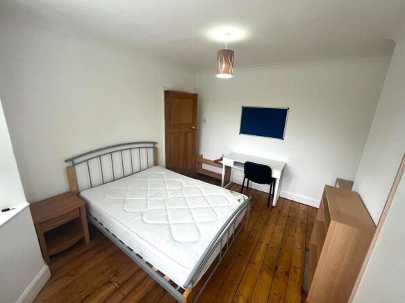Bright, simply furnished bedroom with a double ...