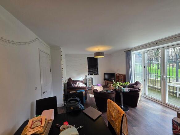 Bright open living room with floor-to-ceiling p...