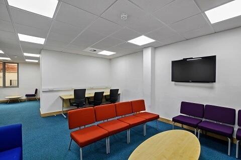 Bright workspace with ample seating and TV...