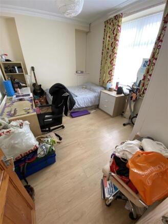 Bright bedroom with wooden floors and large des...