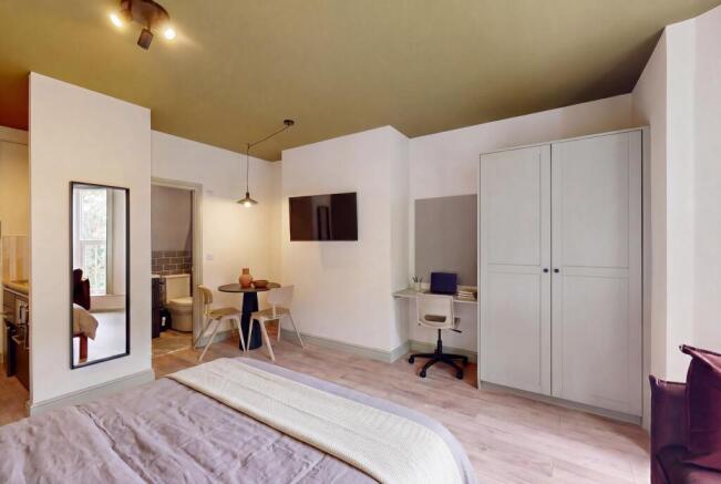 Stylish bedroom with modern workspace and dinin...
