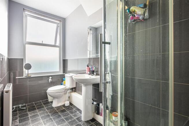 Modern bathroom with large window and glass sho...