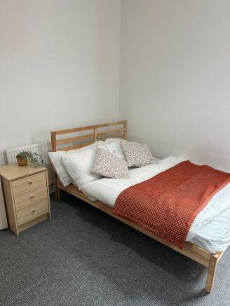 A cozy double bedroom featuring a comfortable b...