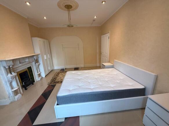 Spacious master bedroom with elegant fireplace...