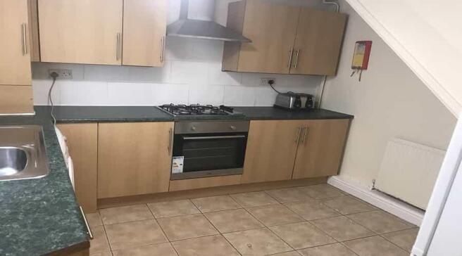 Modern kitchen featuring wooden cabinets, a sta...