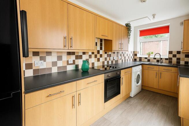 Bright modern kitchen with light wood cabinets,...