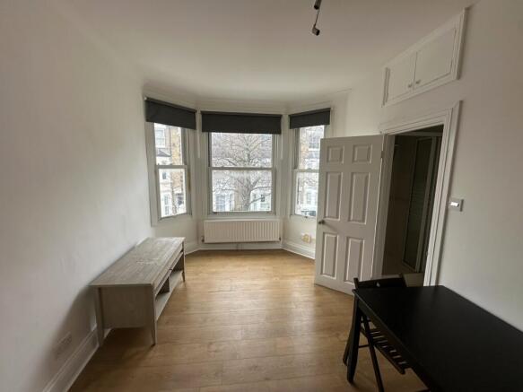 Bright bedroom with bay window and wooden floor...