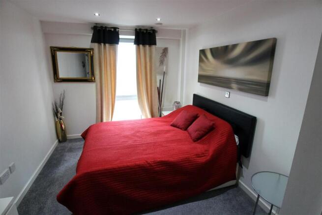 Bright double bedroom with bold red bedding...
