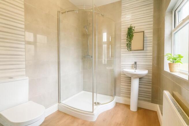 Bright, modern bathroom with a curved glass sho...