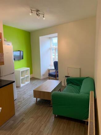 Bright, modern living area with a pop of green ...