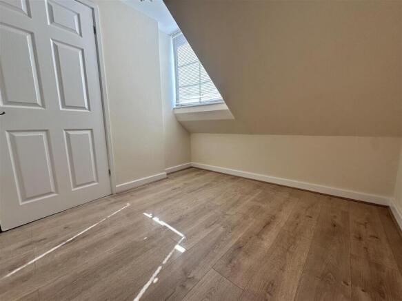 Bright attic room with modern wood floors...