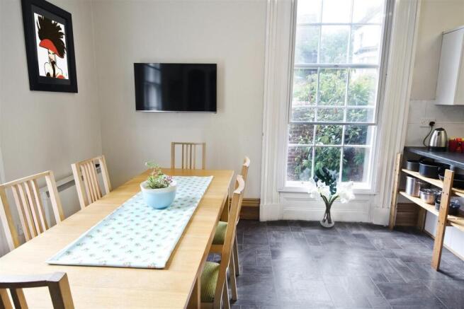 Bright kitchen with a large dining table and TV...