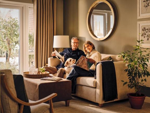 a man and woman sitting on a couch with a dog
