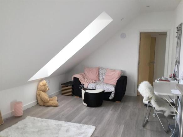 Bright attic bedroom with sloped skylight and d...