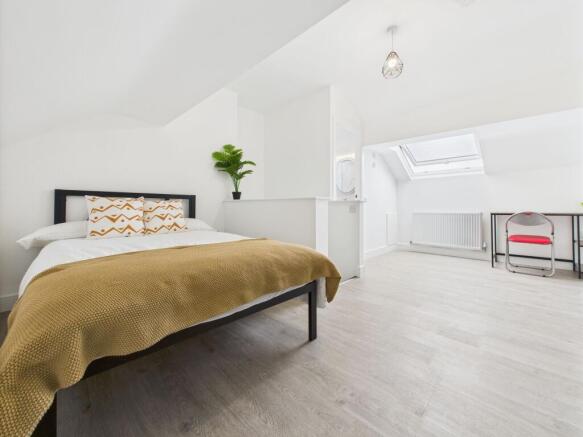 Bright and modern bedroom featuring a comfortab...