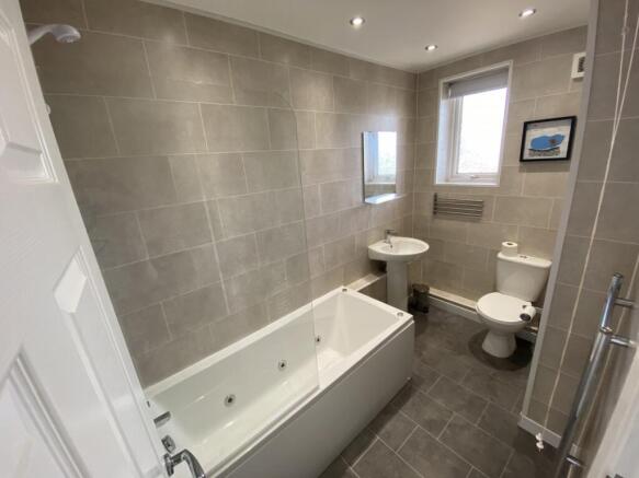 A spacious and modern bathroom featuring a rela...