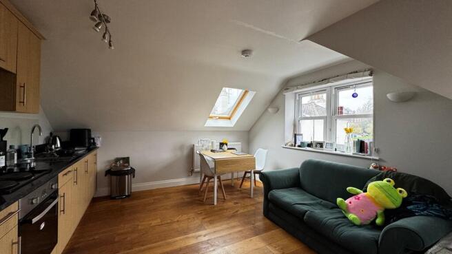 Bright open-plan living area with wooden floors...