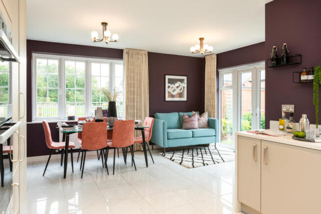 A dining set with coral chairs and a teal sofa are in the foreground