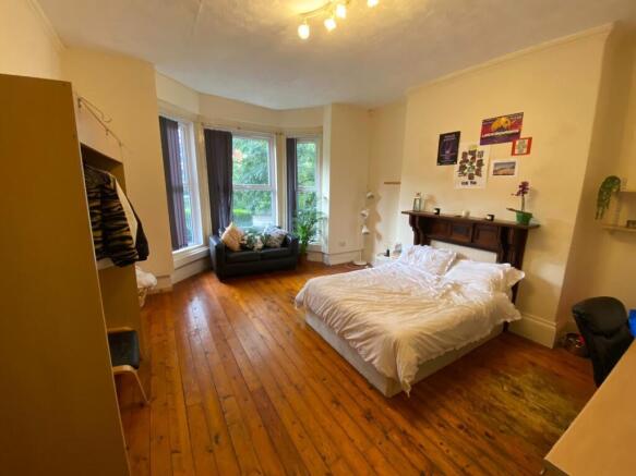 Bright double bedroom with wooden floors, a com...