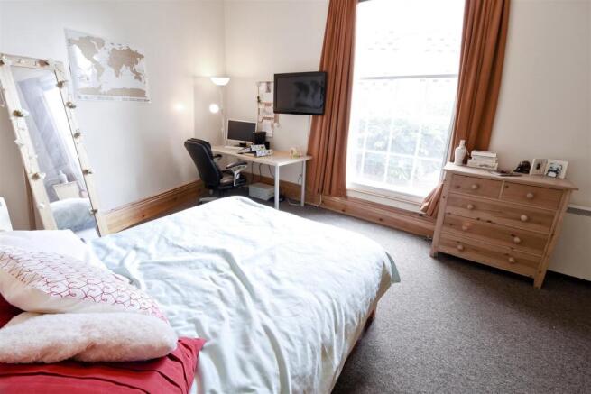 Bright bedroom with large desk and ample storag...