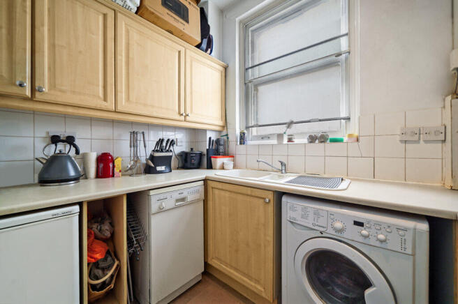 Compact kitchen corner with light wood cabinets, k