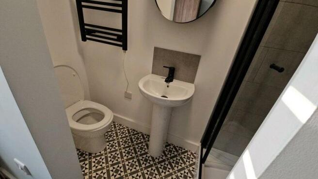 Modern small bathroom with patterned tiled floo...