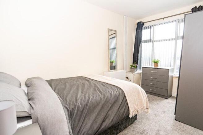 This inviting double bedroom features a comfort...