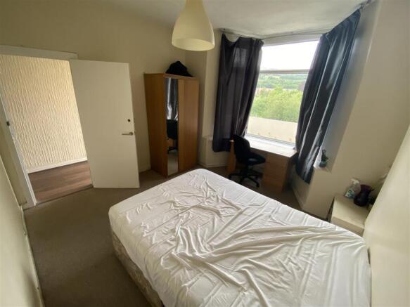 Bright bedroom with large window and study desk...