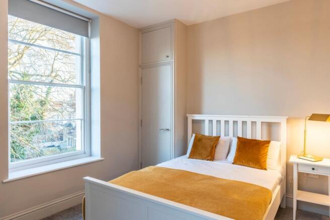Bright, modern bedroom with large sash window...