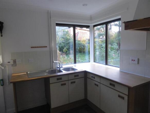 Bright kitchen with large windows and garden vi...