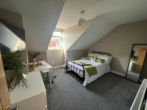 Bright, well-styled attic bedroom with a metal ...