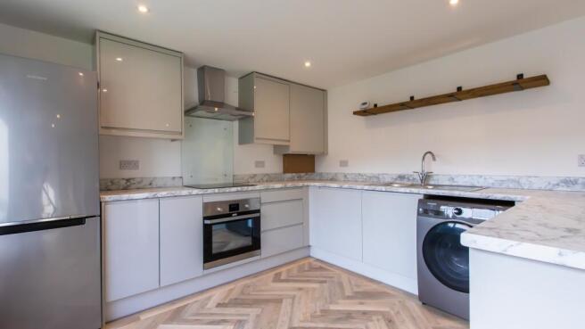 Modern fitted kitchen with marble-effect workto...
