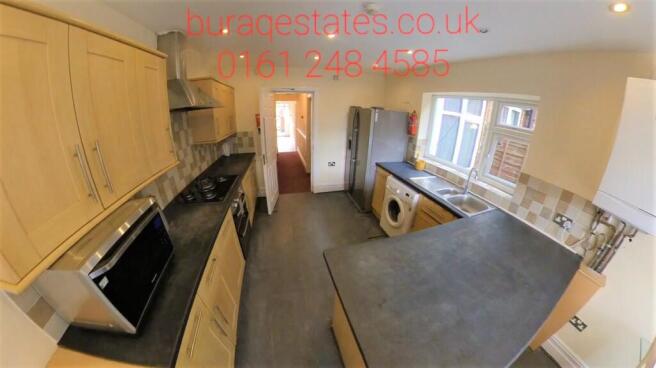 Bright modern kitchen with light wood cabinets,...
