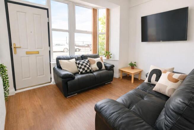 Bright lounge with leather sofas and wall TV...