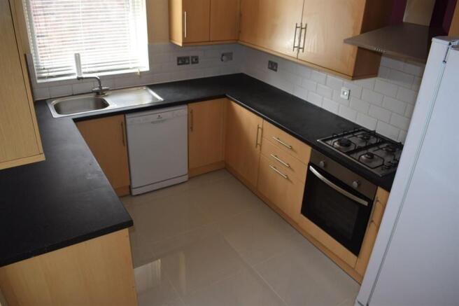 Modern U-shaped kitchen with light wood cabinet...