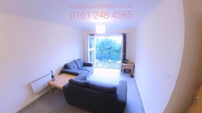 Bright, simply furnished living room with a lar...