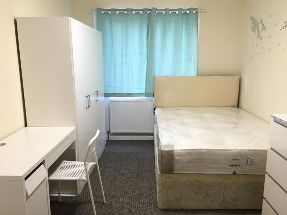 A neat and well-lit double bedroom featuring a ...