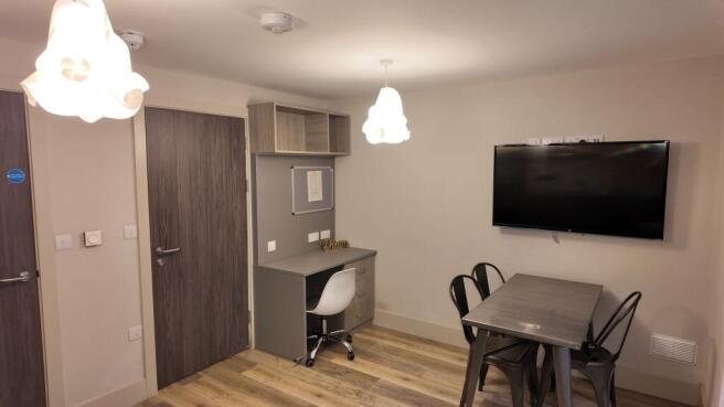 Bright, modern communal lounge with a wall-moun...