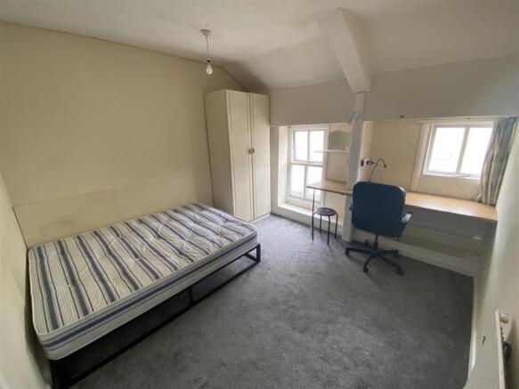 Bright bedroom with large desk and ample storag...