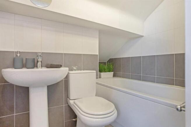 Bright, modern bathroom with clean white sanita...
